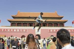 man jumping on pogo stick high above crowd in china square